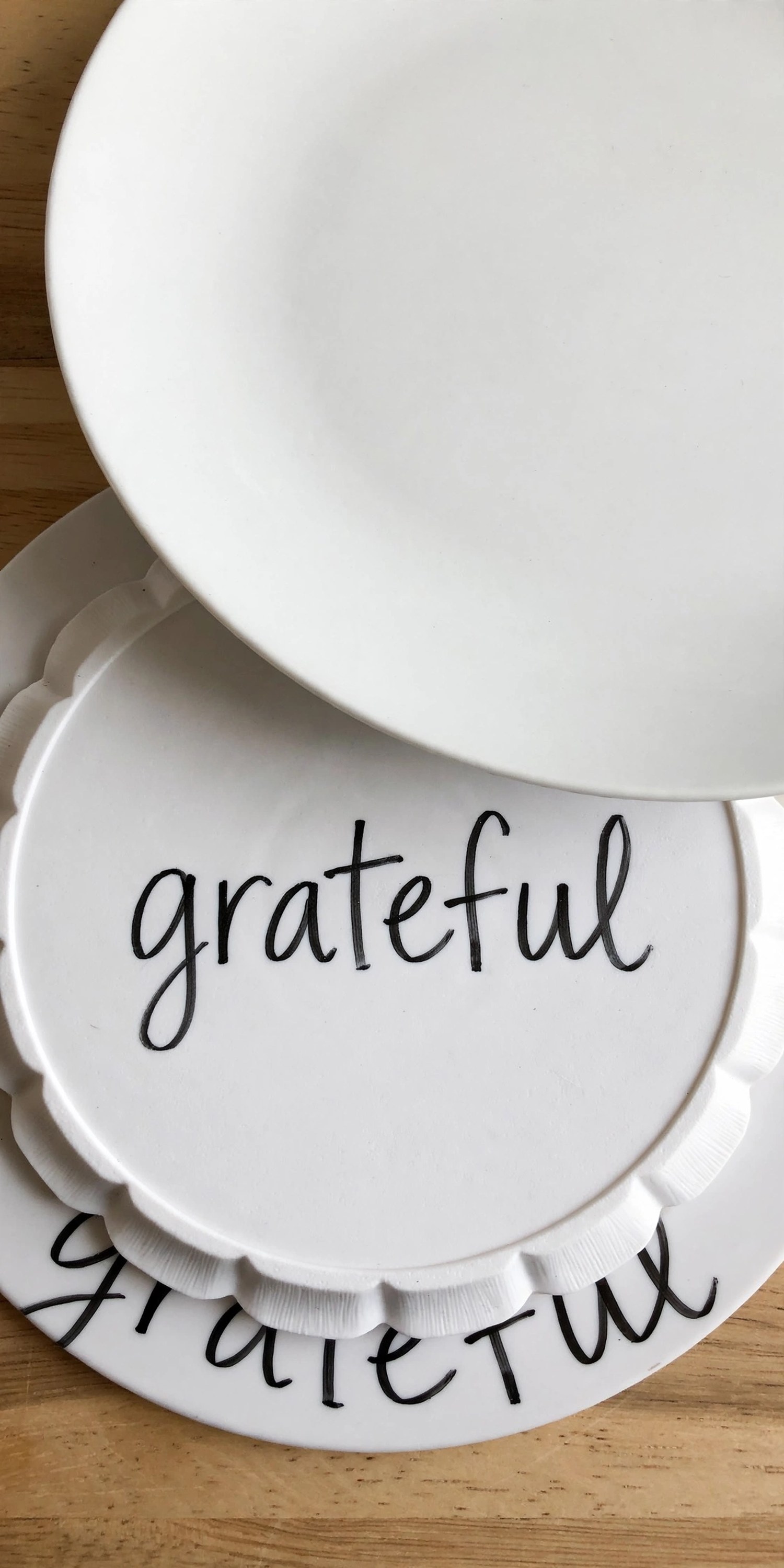 Dollar store chargers hand-lettered with grateful in paint pen