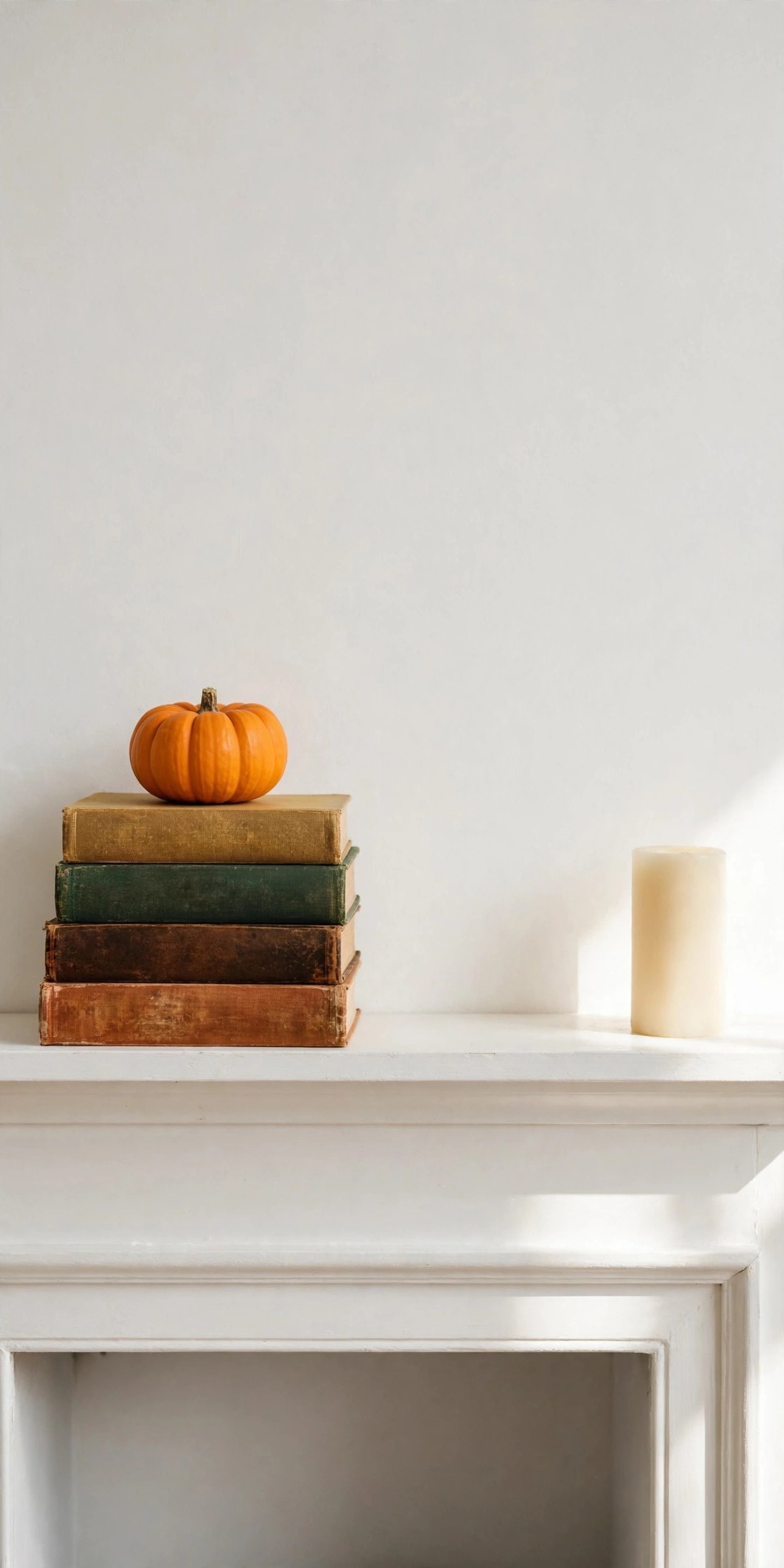 Small orange pumpkin on a stack of vintage hardcover books on a white mantel