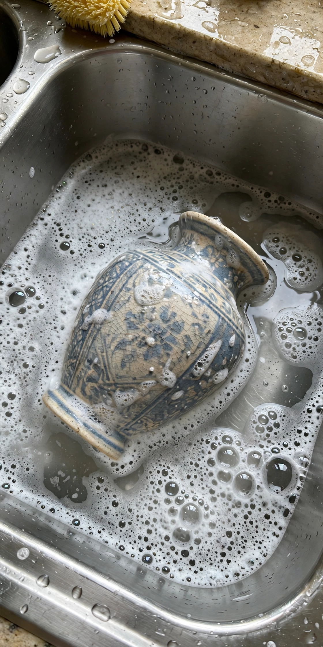 Thrifted vase being washed in a hot soapy soak, cleaning secondhand finds
